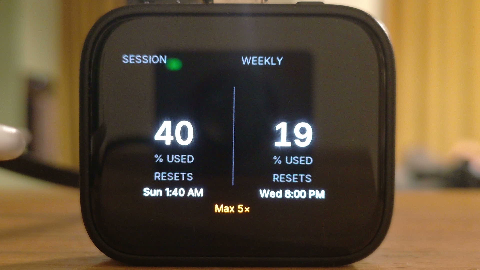 The Deskmate panel on a wooden desk, its screen showing SESSION 40% USED, resets Sunday 1:40 AM, WEEKLY 19% USED, resets Wednesday 8:00 PM, and Max 5× underneath.